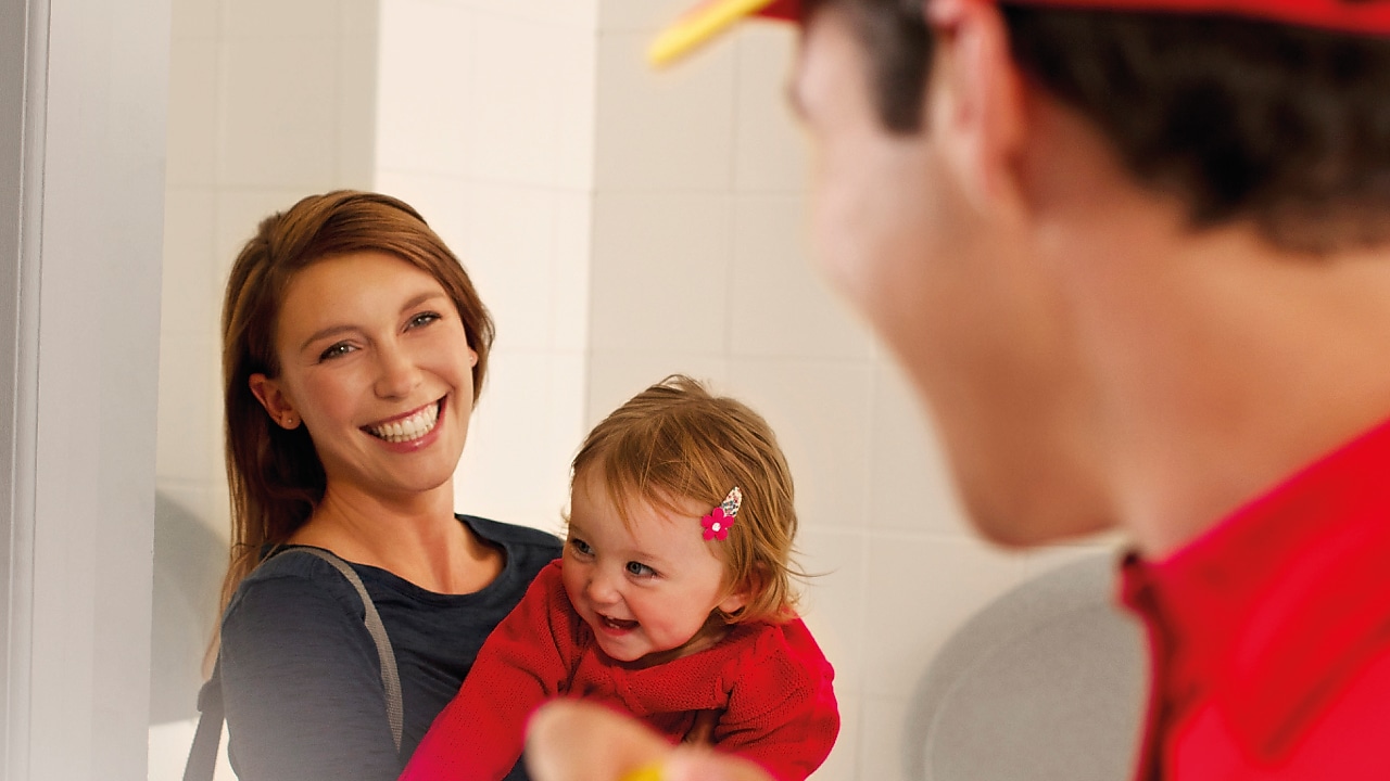 Mulher com criança a sorrir para um colaborador Shell