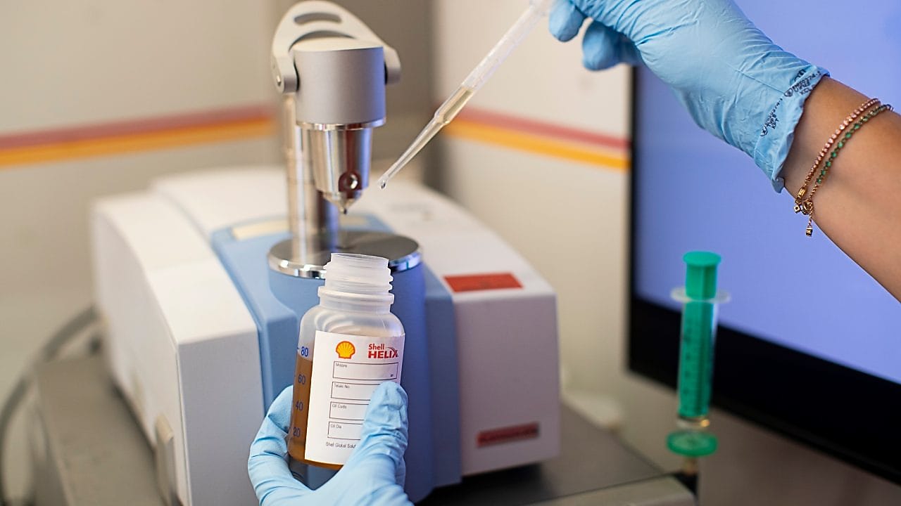 Mão a segurar amostra de Shell V-Power em laboratório